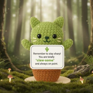 May include: A green crocheted cactus cat with a sign that reads "Remember to stay sharp! You are totally *claw-some* and always on point." The cat is in a brown pot, and the base measures 3cm. The background is a forest scene.