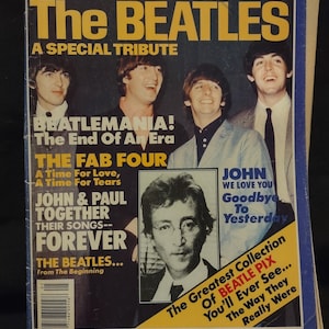 May include: A vintage magazine cover featuring John Lennon and The Beatles. The cover has a yellow and black color scheme with text that reads "JOHN LENNON & The BEATLES" and "A SPECIAL TRIBUTE". The magazine includes images of the band members and text about their music.