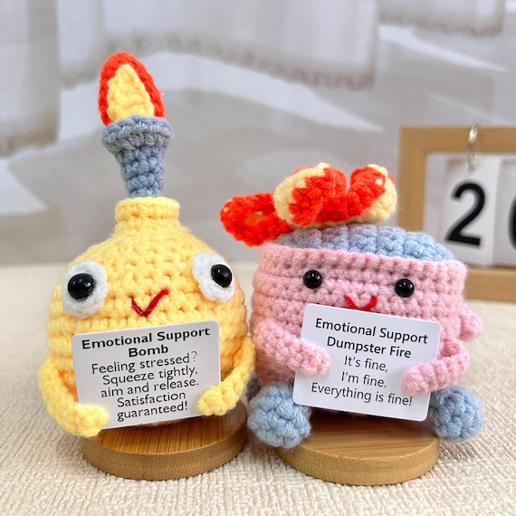 A handmade crochet dumpster fire — literally a tiny flaming trash can you can squeeze for emotional support, and yes, it's as glorious as it sounds.