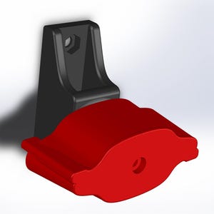 Peut inclure: Un support mural rouge et noir de forme arrondie et incurvée. Le support a un trou au centre et une fente sur le côté.