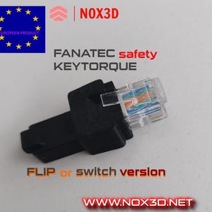 Könnte beinhalten: Ein schwarzer 3D-gedruckter Adapter für ein Fanatec Keytorque-Lenkrad mit einem blauen und orangefarbenen RJ45-Stecker. Der Adapter ist mit "FLIP or switch version" und "www.nox3d.net" beschriftet.