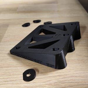 Pu&ograve; includere: Rialzo per skateboard stampato in 3D nero con il testo "NOX3D.NET 15&deg;" sul lato. Il rialzo &egrave; progettato con una forma triangolare e ha pi&ugrave; fori per il montaggio.