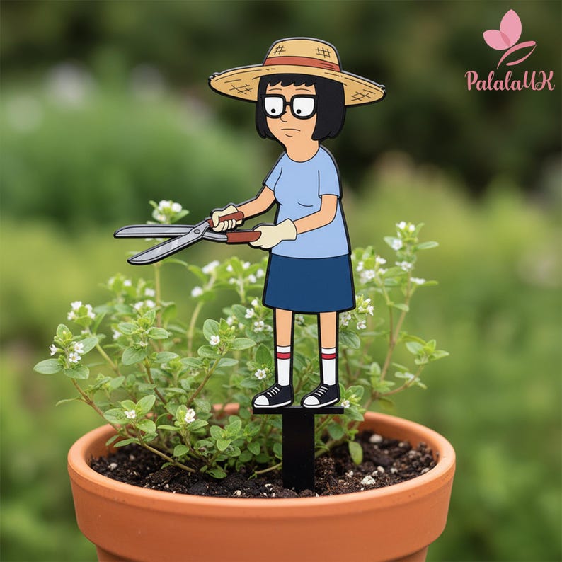 May include: A decorative garden stake featuring a cartoon character with black hair, glasses, and a straw hat, wearing a light blue shirt and dark blue skirt. The character holds metal garden shears and stands on a black base in a plant pot.