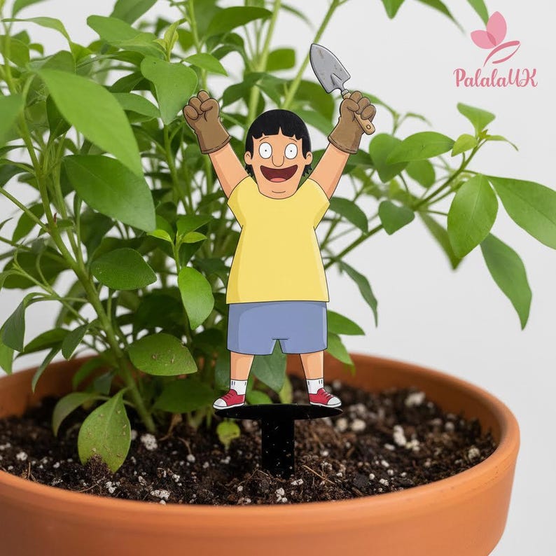 May include: A decorative plant stake featuring a cartoon character with black hair, wearing a yellow t-shirt, blue shorts, white socks, and red sneakers. The character holds a small grey garden trowel in one hand and wears brown gloves.