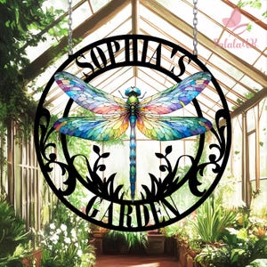 May include: Black metal garden sign with a dragonfly design and the text "Sophia's Garden". The dragonfly has stained glass-like wings with blue, green, yellow, and red colors.