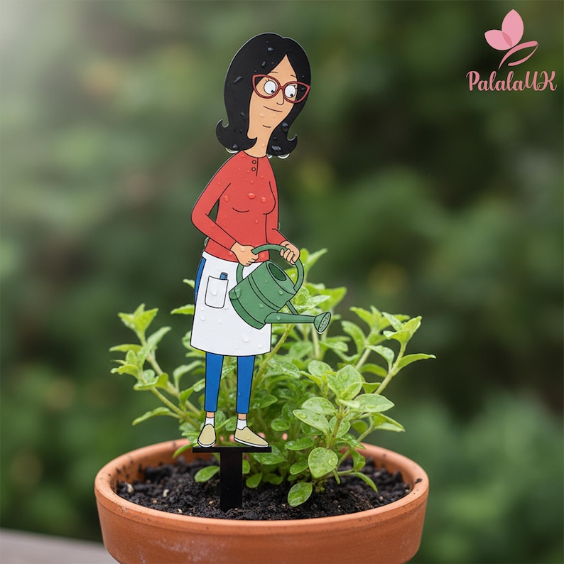 May include: A decorative plant stake featuring a cartoon character with black hair and red glasses, wearing a red long-sleeve shirt, white apron, and blue pants. The character holds a green watering can, designed to be inserted into a potted plant.