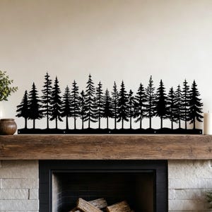 May include: A black metal wall art piece featuring a continuous silhouette of a dense pine forest. The design displays various heights of evergreen trees arranged in a horizontal line, creating a detailed woodland landscape for wall display.