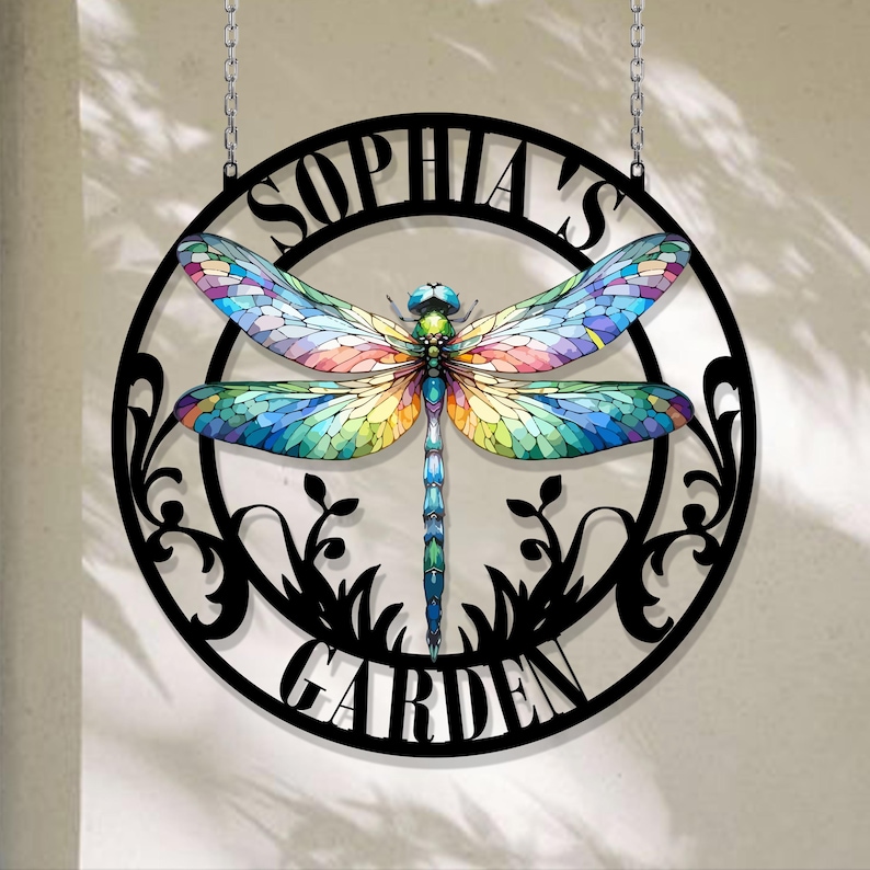 May include: A black metal circle with a cut-out design of a dragonfly and the words "Sophia's Garden".