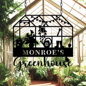 May include: Black metal greenhouse sign with the text "MONROE'S Greenhouse". The sign features silhouettes of gardening tools, plants, and a watering can. The sign is hanging from a chain in front of a greenhouse.