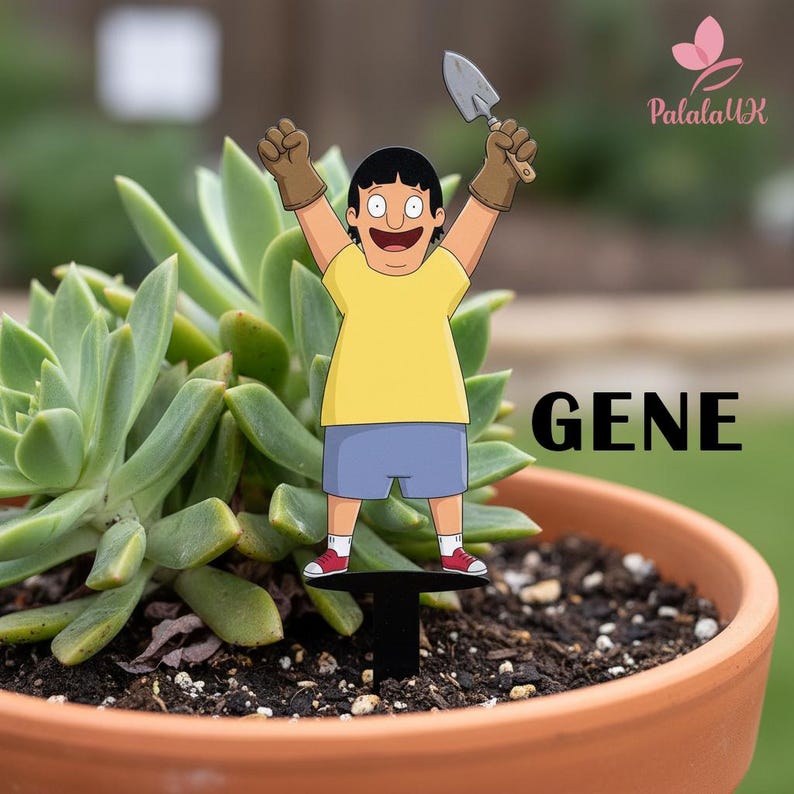 May include: A decorative plant stake featuring a cartoon character named Gene wearing a yellow t-shirt, blue shorts, and brown gardening gloves while holding a small metal trowel. The character stands on a black base inserted into soil.