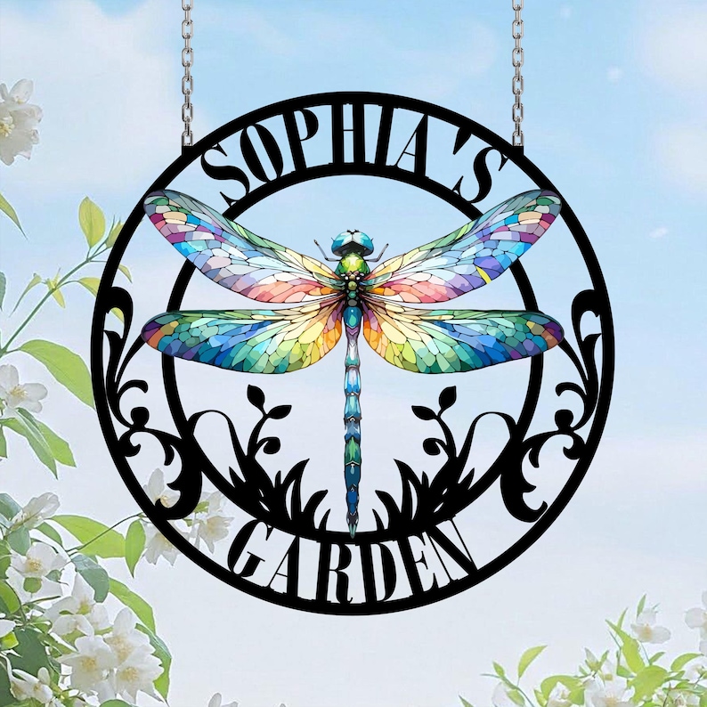 May include: A black metal garden sign with a dragonfly design and the text "Sophia's Garden". The dragonfly has colorful wings with a stained glass effect.