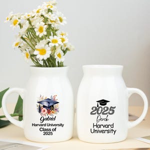May include: Two white ceramic mugs with graduation themed designs. The mug on the left has a floral design and the text "Gabriel Harvard University Class of 2025". The mug on the right has the text "2025 Derick Harvard University".