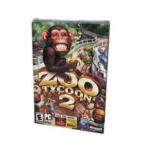 May include: A boxed copy of the "Zoo Tycoon 2" PC game. The cover depicts a cartoon chimpanzee holding a banana, with the game's title in gold. The background shows a zoo scene with animals and visitors.