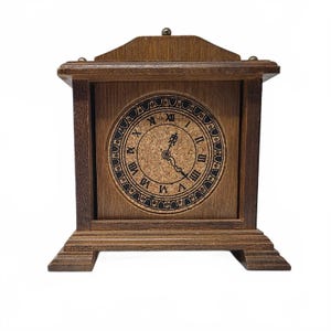 May include: A wooden mantel clock with a rectangular frame and a pediment top. The circular clock face features a cork background with black Roman numerals and ornate black hands. The wood has a medium brown finish with visible grain patterns.