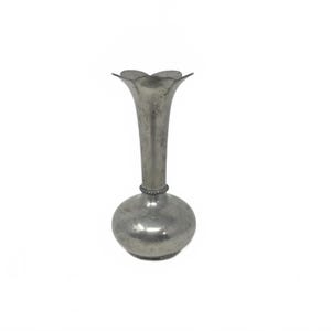 May include: A small, silver-colored vase with a bulbous base and a slender neck that flares into a four-petal flower shape. The vase has a textured surface and a decorative band near the neck. A decorative piece for the home.