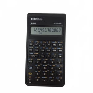 May include: A black Hewlett Packard 20S scientific calculator with a display showing the number 123,456,789.000. The calculator has numerous buttons for scientific functions and calculations. The calculator is designed for mathematical and scientific use.