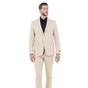 May include: A beige suit with a black dress shirt. The suit includes a two-button jacket with notched lapels and matching trousers. The man is wearing black dress shoes.