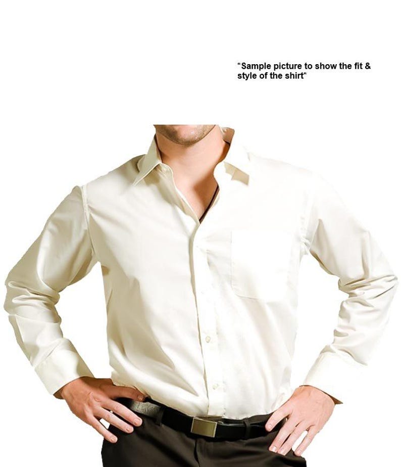 May include: A white long-sleeved dress shirt with a button-down collar and a single chest pocket. The shirt is tucked into black pants with a black belt.