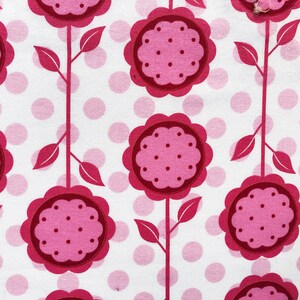 May include: White fabric with a repeating pattern of pink flowers with white polka dots and pink polka dots on a white background.