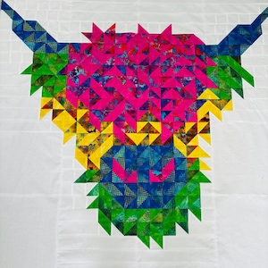 Puede incluir: Un bloque de colcha colorido con un diseño estilizado de una vaca de las Tierras Altas. La vaca está hecha de triángulos de tela rosa, amarillo, azul y verde.