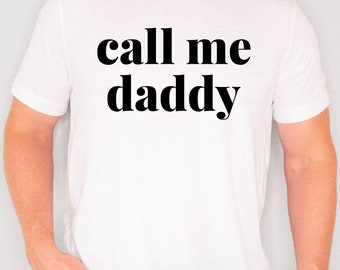 May include: White t-shirt with the text "call me daddy" printed in black.