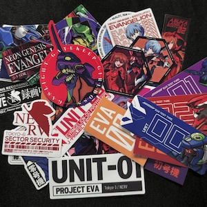 May include: A collection of colorful anime-themed stickers featuring characters and logos from the Neon Genesis Evangelion series. The stickers include various shapes and sizes, with text such as "UNIT-01" and "EVA".