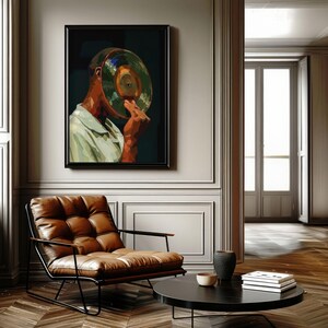 May include: A framed art print depicts a person with a vinyl record covering their face. The artwork features a color palette of green, brown, and white. The room includes a brown leather armchair and a black coffee table.