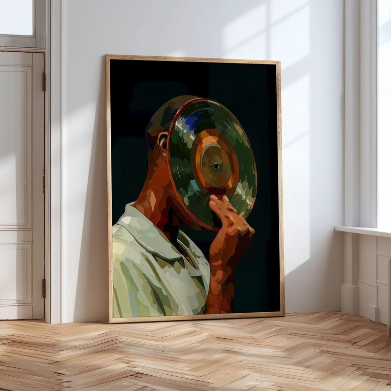 May include: A framed art print featuring a person with a vinyl record covering their face. The artwork has a dark background and a wooden frame. The person is wearing a light green shirt.