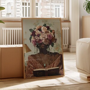 Puede incluir: Una impresi&oacute;n enmarcada de una mujer con un ramo de flores rosas, blancas y moradas que le cubren la cara. Lleva un su&eacute;ter marr&oacute;n y sostiene un libro. El fondo es un patr&oacute;n floral verde claro y blanco.