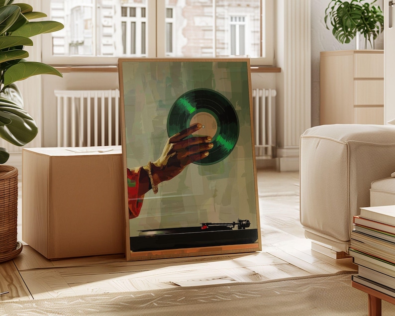 May include: A framed art print featuring a hand holding a green vinyl record. The artwork has a vintage aesthetic, with a turntable in the foreground. The hand has gold painted nails and is wearing a bracelet. The background is a muted green.