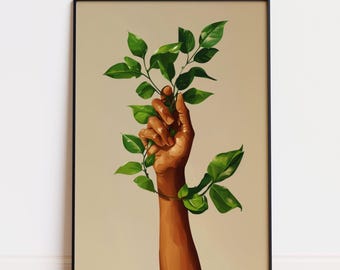 May include: A framed art print depicting a hand with brown skin grasping a verdant green leafy branch. The artwork has a neutral background and is framed in black. The image suggests themes of nature and growth.