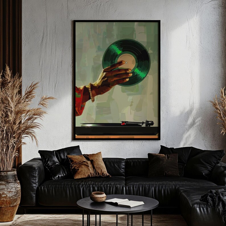 May include: A framed art print featuring a hand holding a green vinyl record above a black turntable. The artwork has a retro aesthetic with a muted color palette, and the hand is adorned with a bracelet. The background is a blend of green and gray.