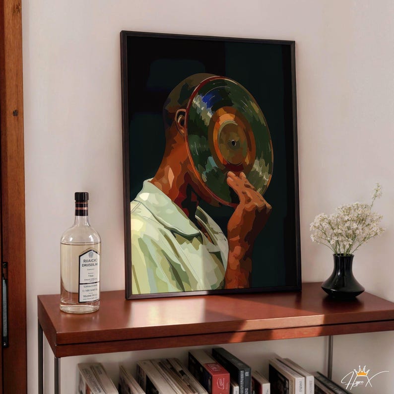 May include: A framed art print featuring a stylized illustration of a person with a vinyl record covering their face. The artwork has a dark background and is displayed on a wooden shelf with a bottle and a vase of flowers.
