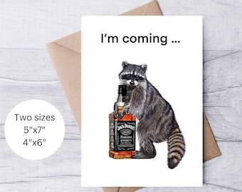May include: A greeting card with a raccoon holding a bottle of Jack Daniel's whiskey. The card says "I'm coming..." and is available in two sizes: 5"x7" and 4"x6".