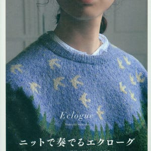 Puede incluir: Una persona lleva un suéter de punto azul con motivos de pájaros amarillos. La portada del libro muestra el título "Eclogue" y texto japonés. El fondo muestra una escena de bosque.