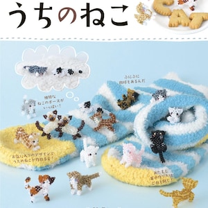 Puede incluir: Portada de libro con texto japonés e imágenes de gatos de cuentas. El título, "Mis gatos", está escrito en japonés. La portada muestra varias figuras de gatos de cuentas en diferentes colores y poses, sobre un fondo a rayas azules y blancas.