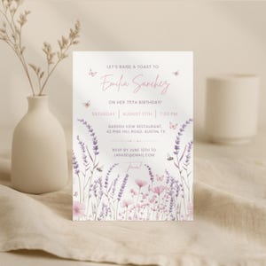 May include: A floral invitation with the text "Let's Raise a Toast to Emilia Sanchez on her 75th Birthday!" The invitation includes the date, time, and location. Lavender and pink flowers and butterflies decorate the card.