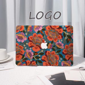 K&ouml;nnte beinhalten: Eine Laptop-H&uuml;lle mit einem lebendigen Blumenmuster in Orange, Rosa und Wei&szlig; auf t&uuml;rkisfarbenem Hintergrund. Die H&uuml;lle zeigt das Apple-Logo und das Wort "LOGO" in einer Schreibschrift. Die H&uuml;lle befindet sich auf einer wei&szlig;en Oberfl&auml;che.