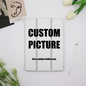 May include: White Kindle case with the text "CUSTOM PICTURE" and the words "Has a unique kindle case" printed on it.