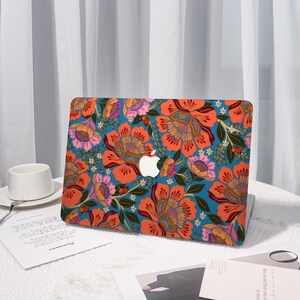 K&ouml;nnte beinhalten: Eine Laptop-H&uuml;lle mit einem lebendigen Blumenmuster in Orange-, Rosa- und Gelbt&ouml;nen auf einem t&uuml;rkisfarbenen Hintergrund. Das Design umfasst detaillierte Blumenillustrationen und gr&uuml;ne Bl&auml;tter. Das Apple-Logo ist in der Mitte sichtbar.