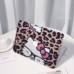 Op de afbeelding: Laptophoesje met een luipaardprint en een cartoonkat met een bril en een roze strik. De hoes is beige, bruin, wit en roze. De laptop staat op een wit oppervlak.
