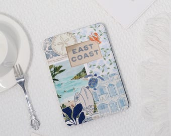 May include: A rectangular coaster with a collage design featuring beach scenes, a sand dollar, and the text "EAST COAST." The coaster has a blue and white floral pattern and images of a lobster and a turtle.