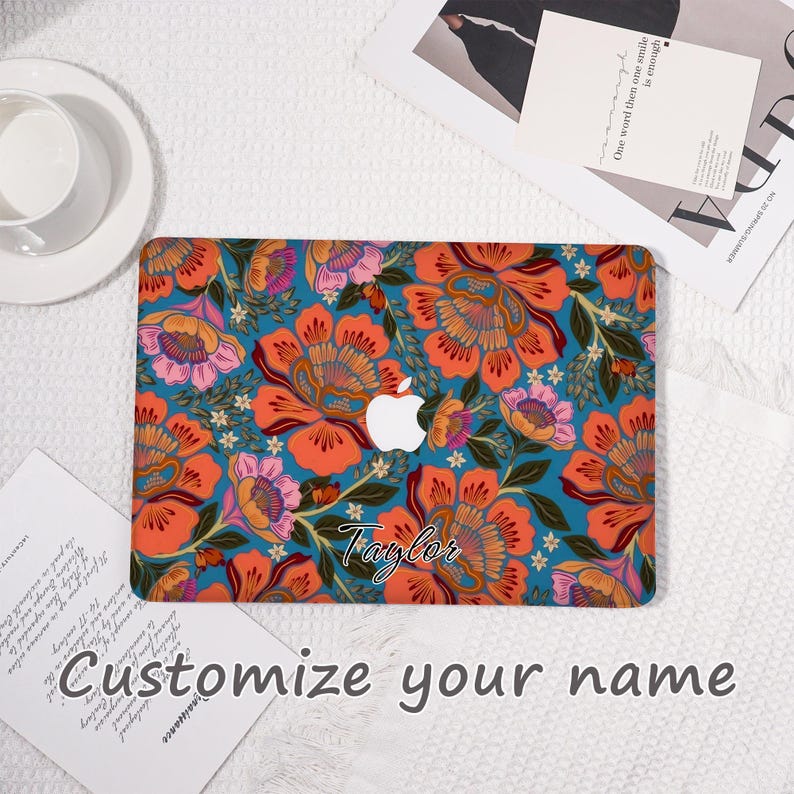 K&ouml;nnte beinhalten: Eine t&uuml;rkisfarbene Laptop-H&uuml;lle mit einem lebendigen Blumenmuster in Orange, Rosa und Gelb. Das Design enth&auml;lt den Namen "Taylor" in Schreibschrift und das Apple-Logo. Der Text "Customize your name" ist ebenfalls sichtbar.