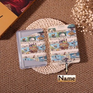 May include: A clear plastic case and a notebook featuring a whimsical illustration with musical notes and cartoon characters. The notebook has the text "JOES JUBILEE" and "Monica" written on it.