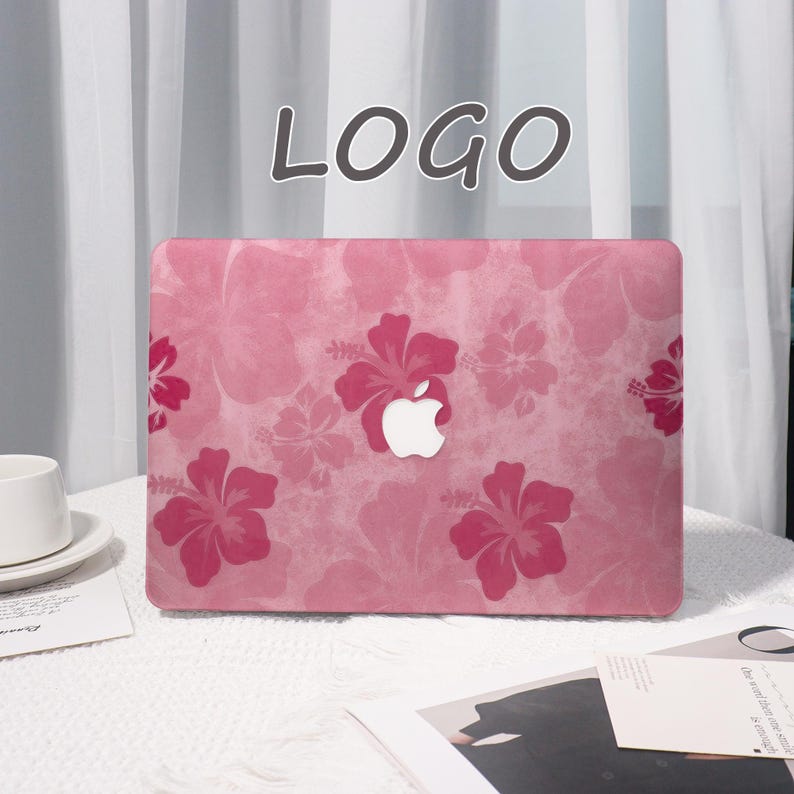 May include: Pink laptop case with a floral hibiscus pattern. The case features a white Apple logo in the center and the word "LOGO" at the top. The design includes various shades of pink and red.