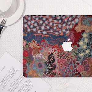 May include: A laptop cover featuring a colorful, abstract design with red, blue, and white patterns. The cover has a white Apple logo in the center. The design is reminiscent of an artistic painting.