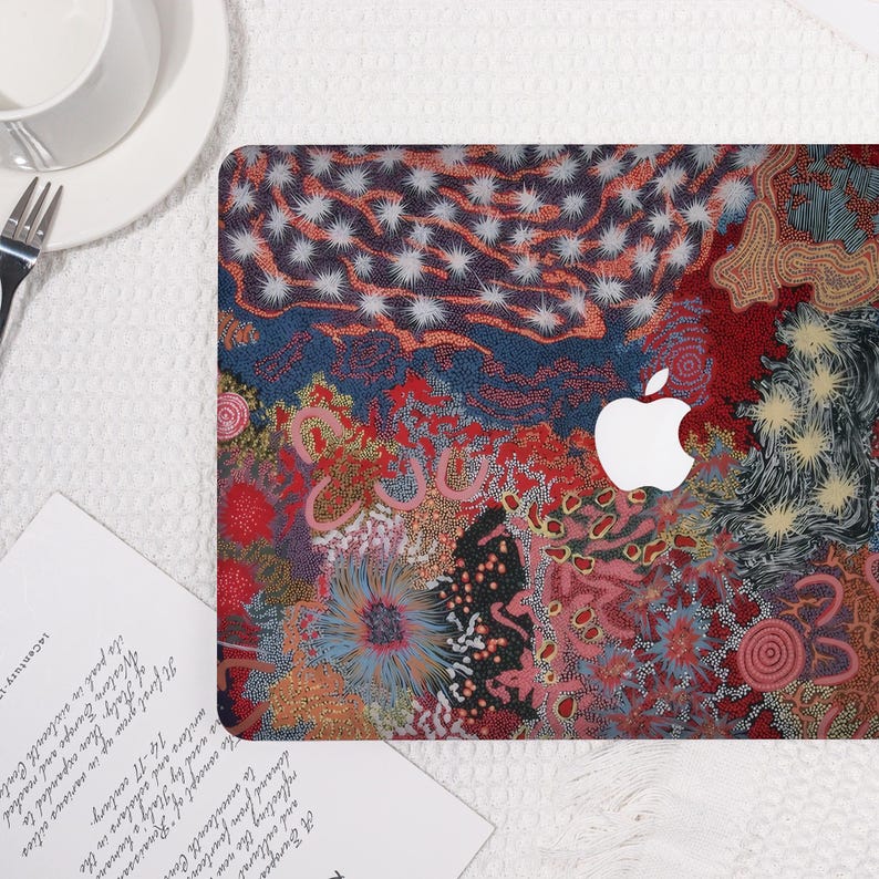 May include: A laptop cover featuring a colorful, abstract design with red, blue, and white patterns. The cover has a white Apple logo in the center. The design is reminiscent of an artistic painting.
