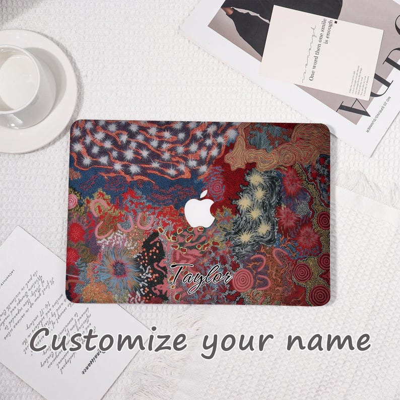 May include: A laptop cover with a colorful abstract design in red, blue, and gold. The cover features the Apple logo and the name "Taylor" in script. The text "Customize your name" is also visible.