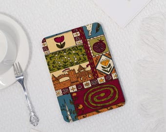 Könnte beinhalten: Rechteckiger Untersetzer mit einem farbenfrohen, gemusterten Design. Das Design zeigt ein Schloss, Blumen und eine Schlange im Patchwork-Stil. Der Untersetzer hat einen cremefarbenen Hintergrund und ist wahrscheinlich aus Stoff.