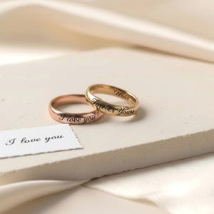 Peut inclure: Deux bagues en m&eacute;tal &agrave; la finition lisse, l'une dans un ton or rose et l'autre dans un ton or jaune. La bague en or rose est grav&eacute;e du texte I love you, et la bague en or jaune est grav&eacute;e du texte Forever Yours. Une petite carte blanche avec le texte I love you est incluse.